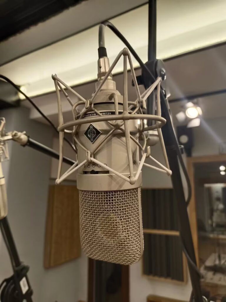 Grabación de voces con micrófono Neumann U87 en La Joya Music.